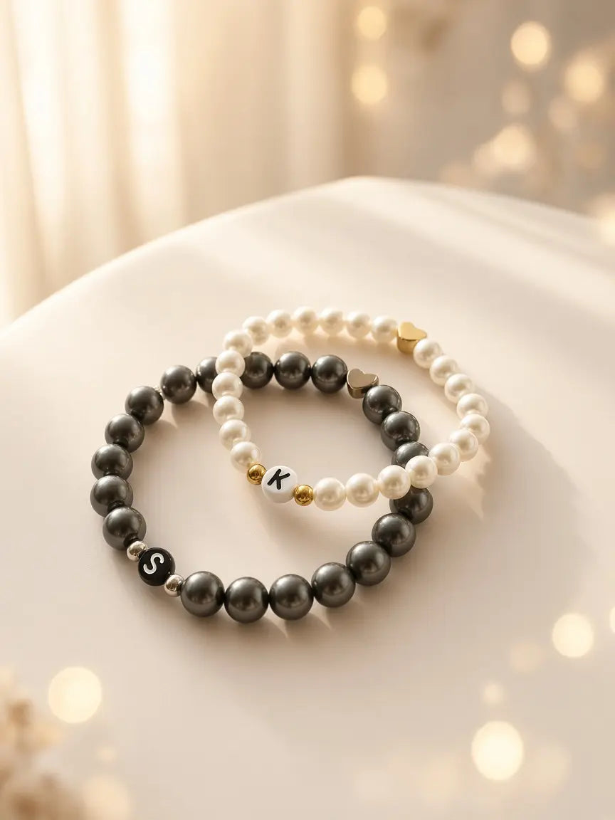 Personalisierte Perlenarmbänder in Weiß und Schwarz mit Buchstabenperle und goldener Herzperle