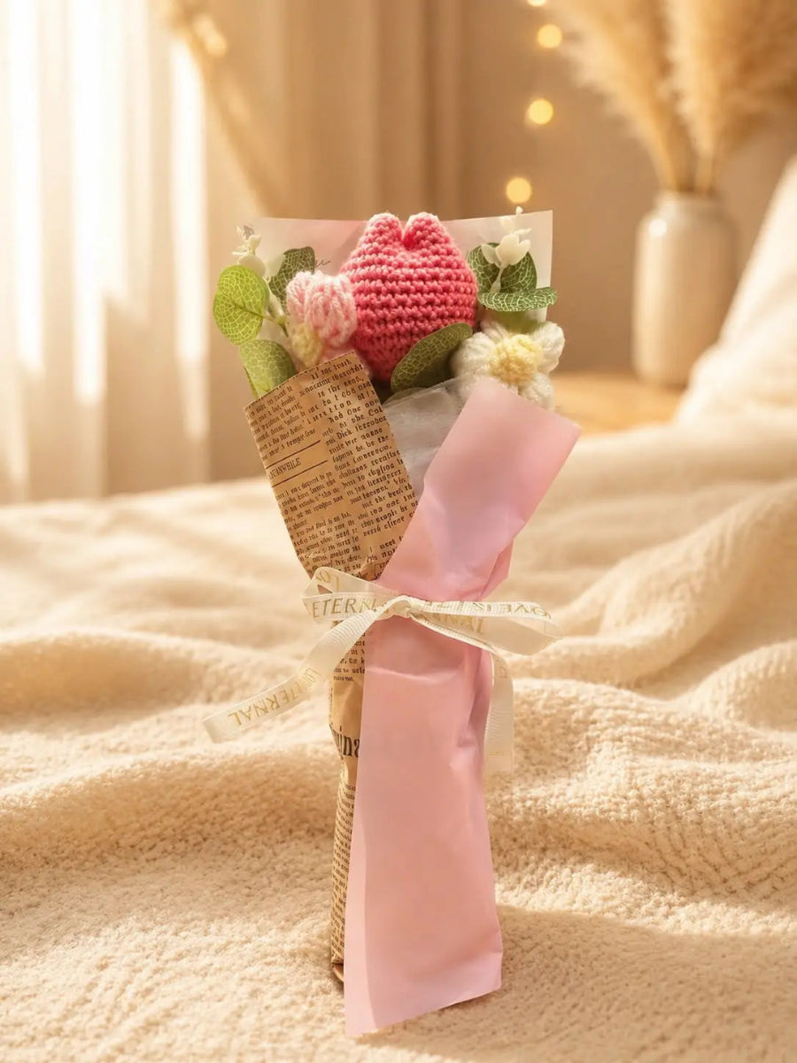 Gehäkelter Blumenstrauß mit rosa Tulpe und Gänseblümchen als Geschenk