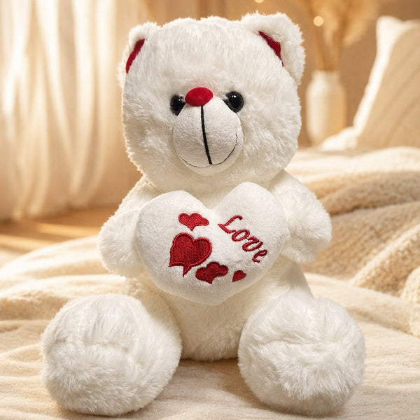Weißer Teddybär mit rotem Love-Herz in den Pfoten